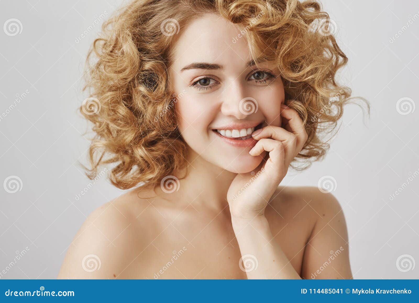 Waist Up Portrait Of Sensually Attractive European Woman With Short Curly Hair Biting Finger