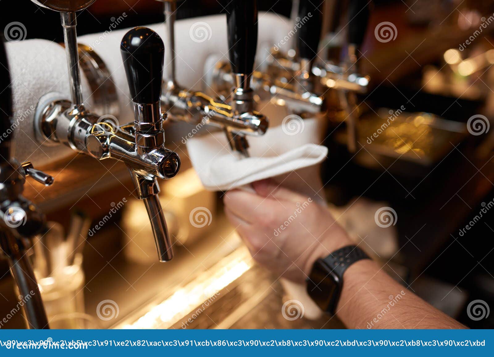 Waiter or Bartender Cleaning Beer Taps on the Counter in Pub and
