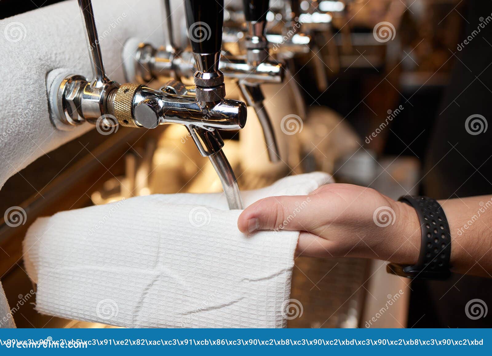 Waiter or Bartender Cleaning Beer Taps on the Counter in Pub and