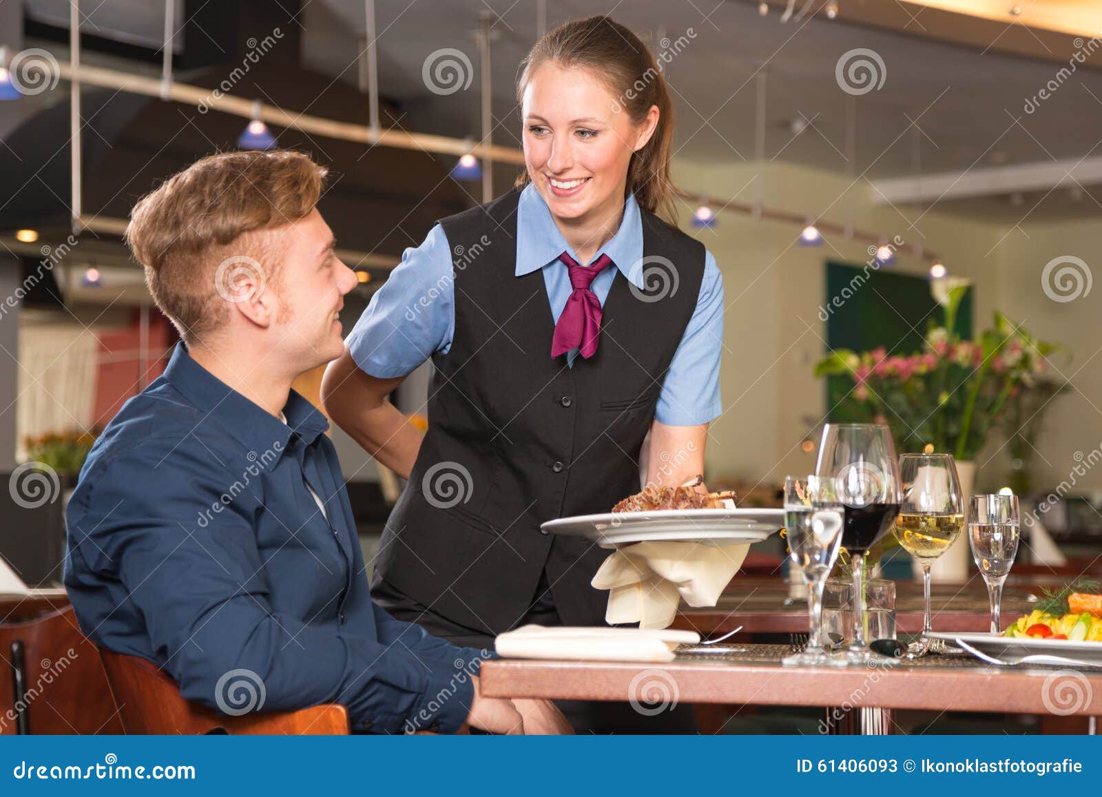 waitress serving the meal to guest in restaurant