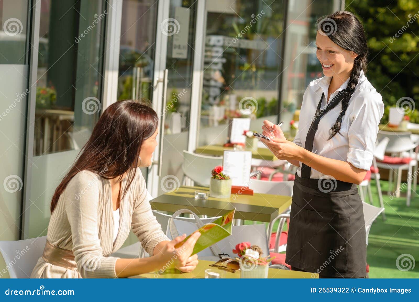 waitress taking woman's order at cafe bar