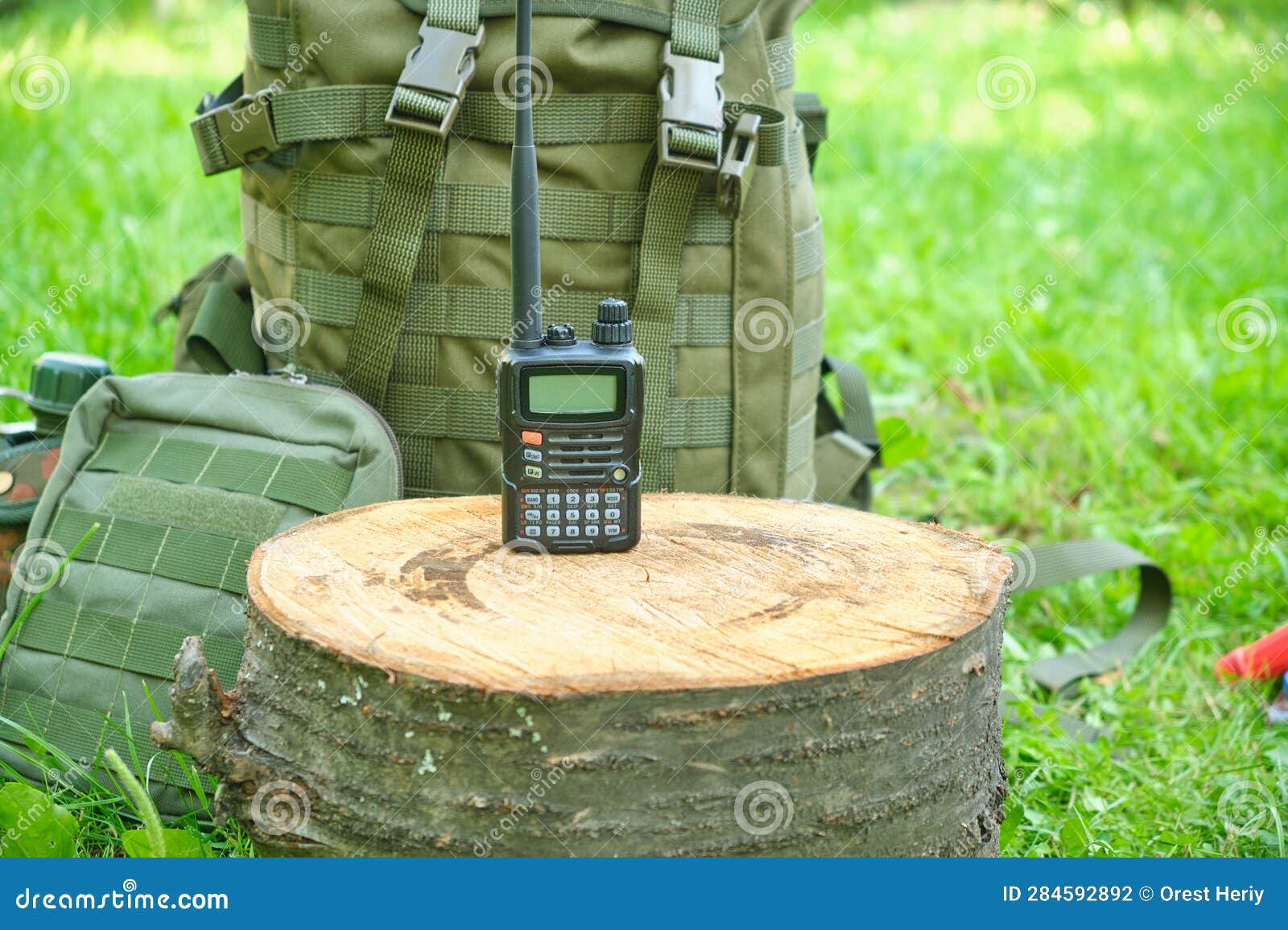 A Walkietalkie and a Military Tactical Backpack. in Nature Stock Photo