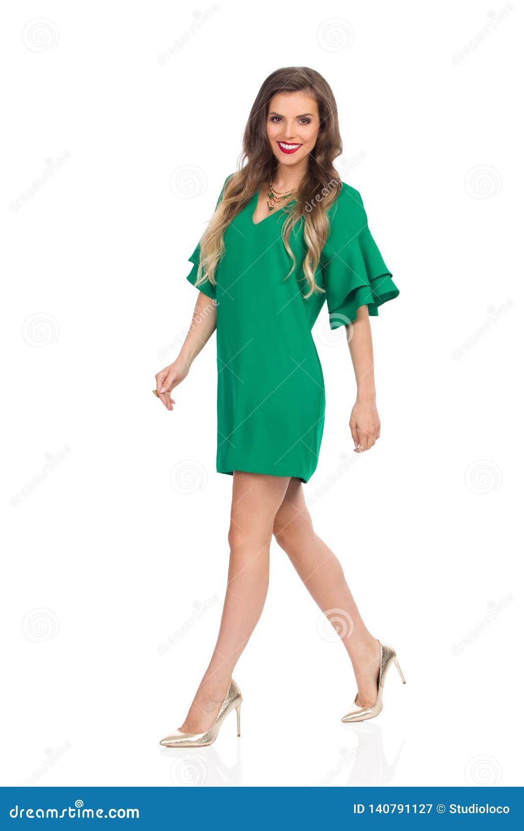 Beautiful Young Woman in Green Mini Dress and High Heels is Walking and ...