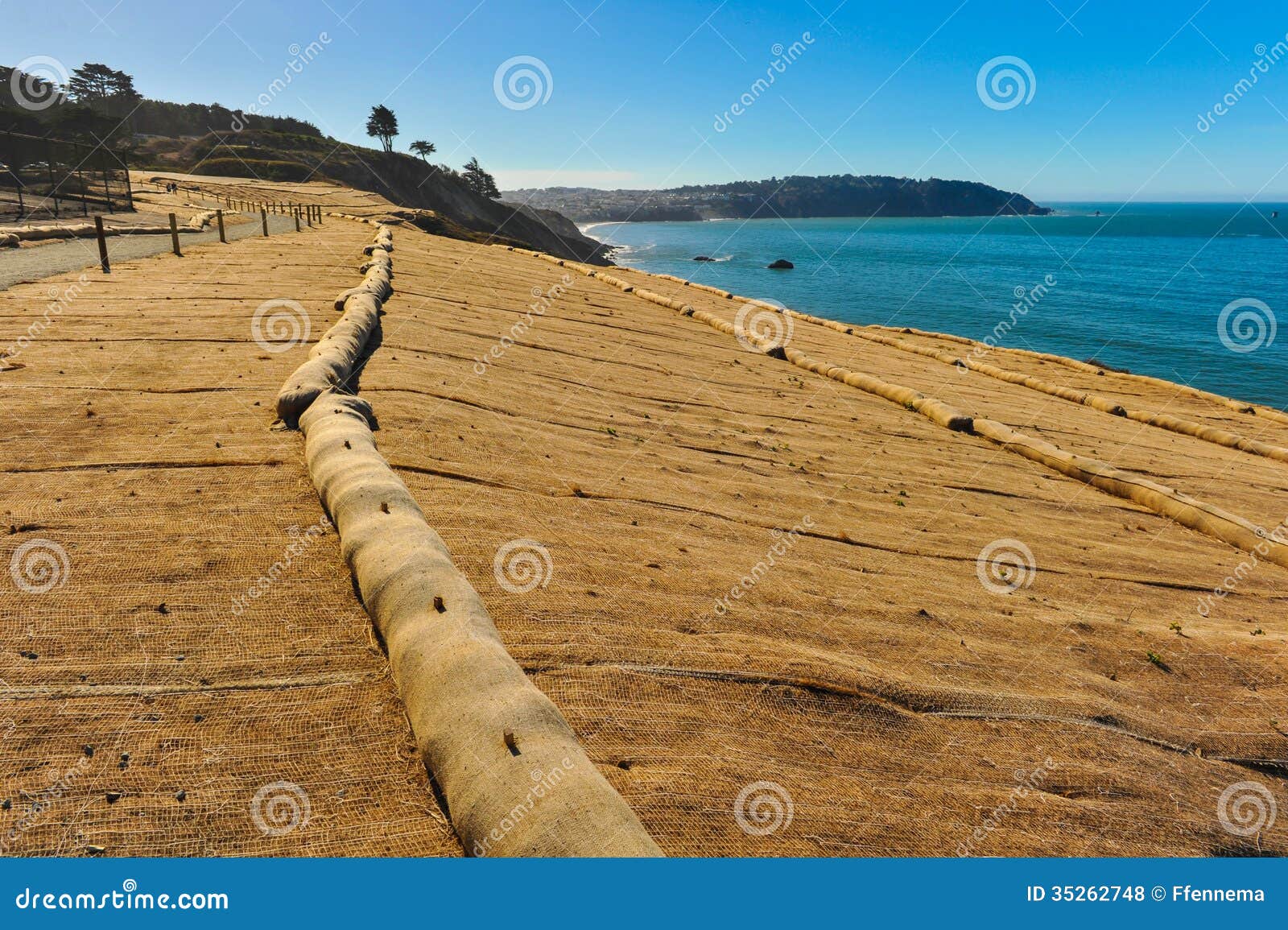 walking trail next to ocean with erosion control mesh