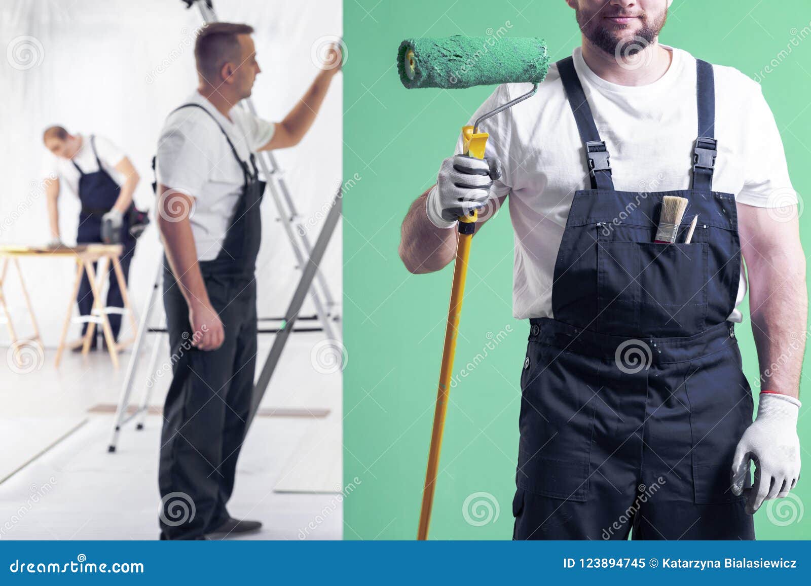 wall painter in dungarees holding a paint roller on a neo mint g