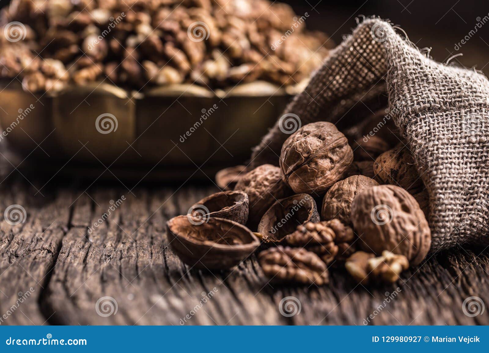 walnut kernels whole walnuts in burlap sack and vintage bowl