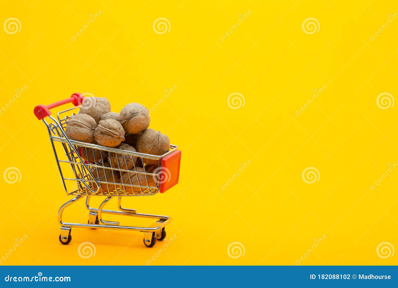 Walnuts are in the Grocery Basket, Bright Orange Background Stock Photo