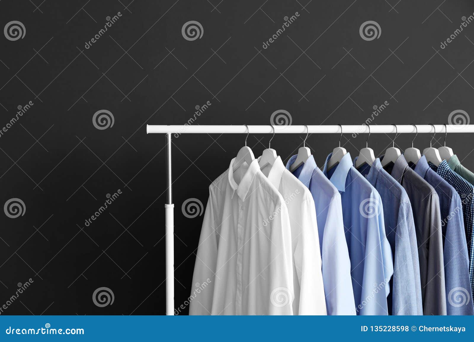 Wardrobe Rack with Men`s Clothes Against Grey Background. Stock Photo