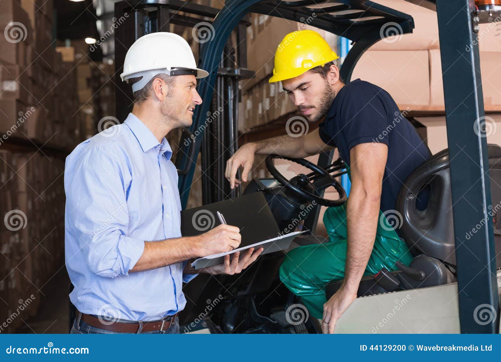 warehouse manager talking with forklift driver