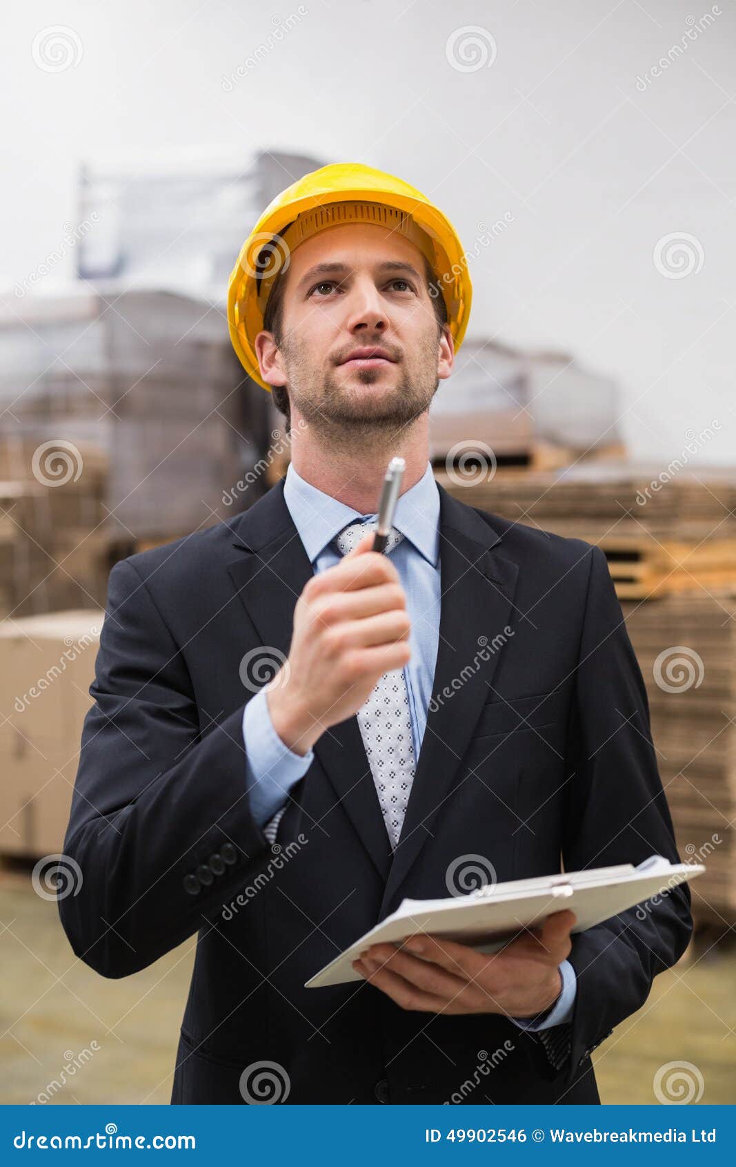 Warehouse Manager Wearing Hard Hat Checking Inventory Stock Photo