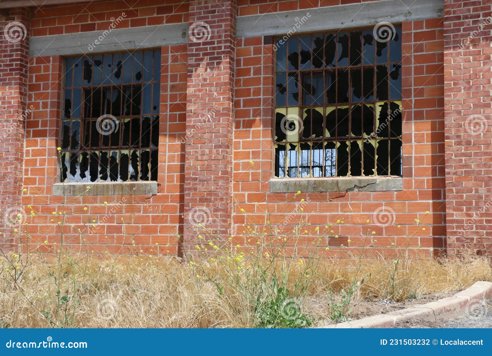 smashed window panes in an abandoned brick warehouse.