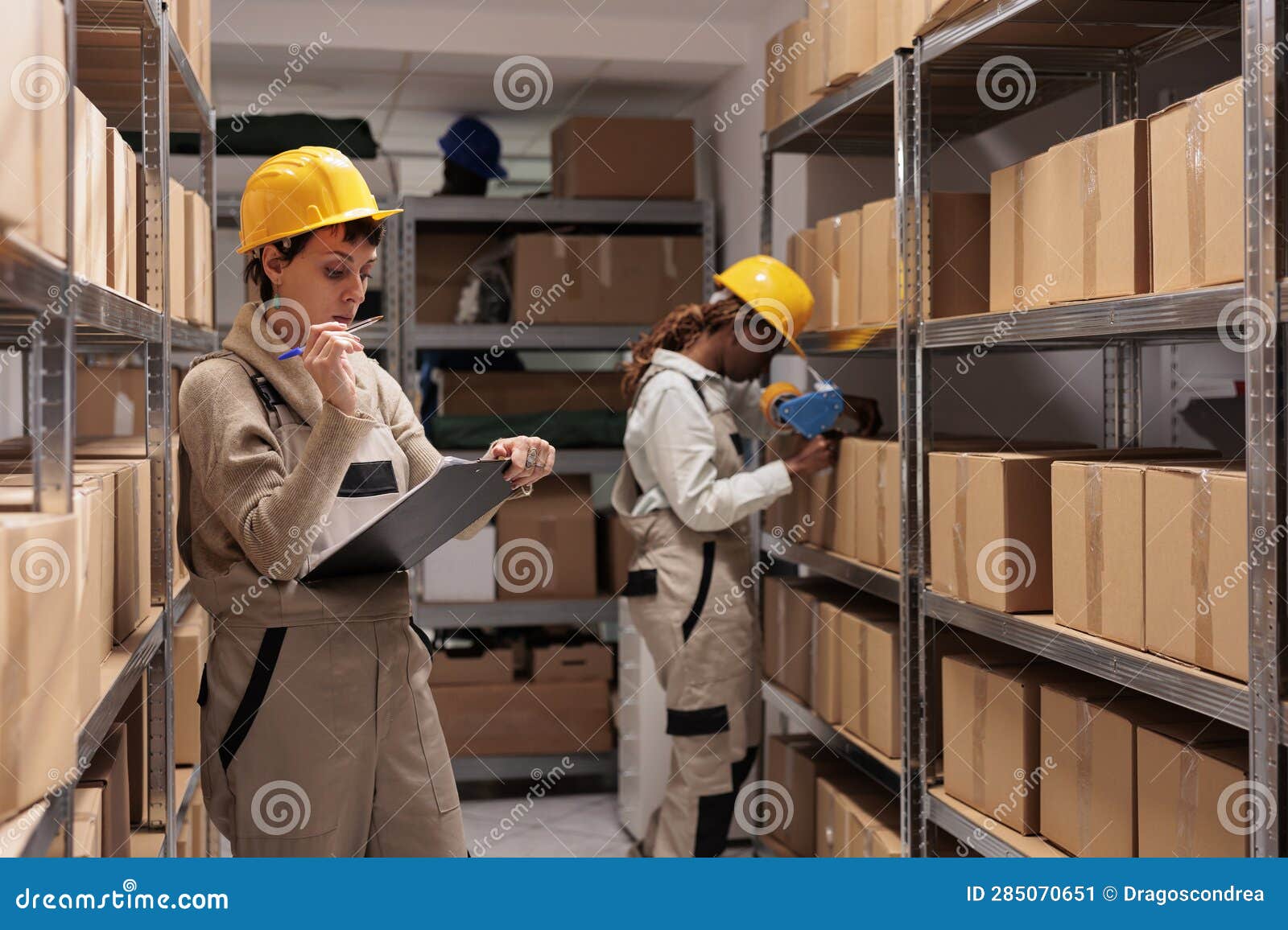 Warehouse Operative Looking at Checklist on Clipboard, Counting Boxes