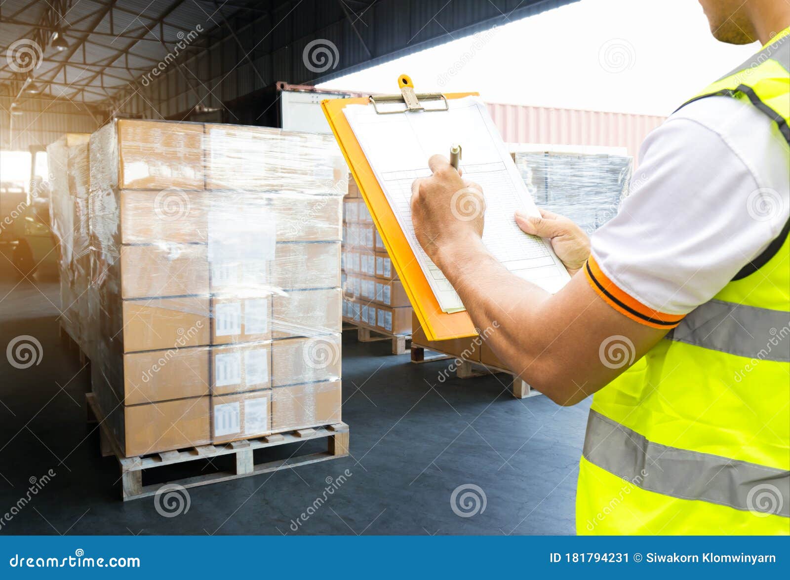 warehouse worker courier hand holding clipboard inspecting load shipment goods