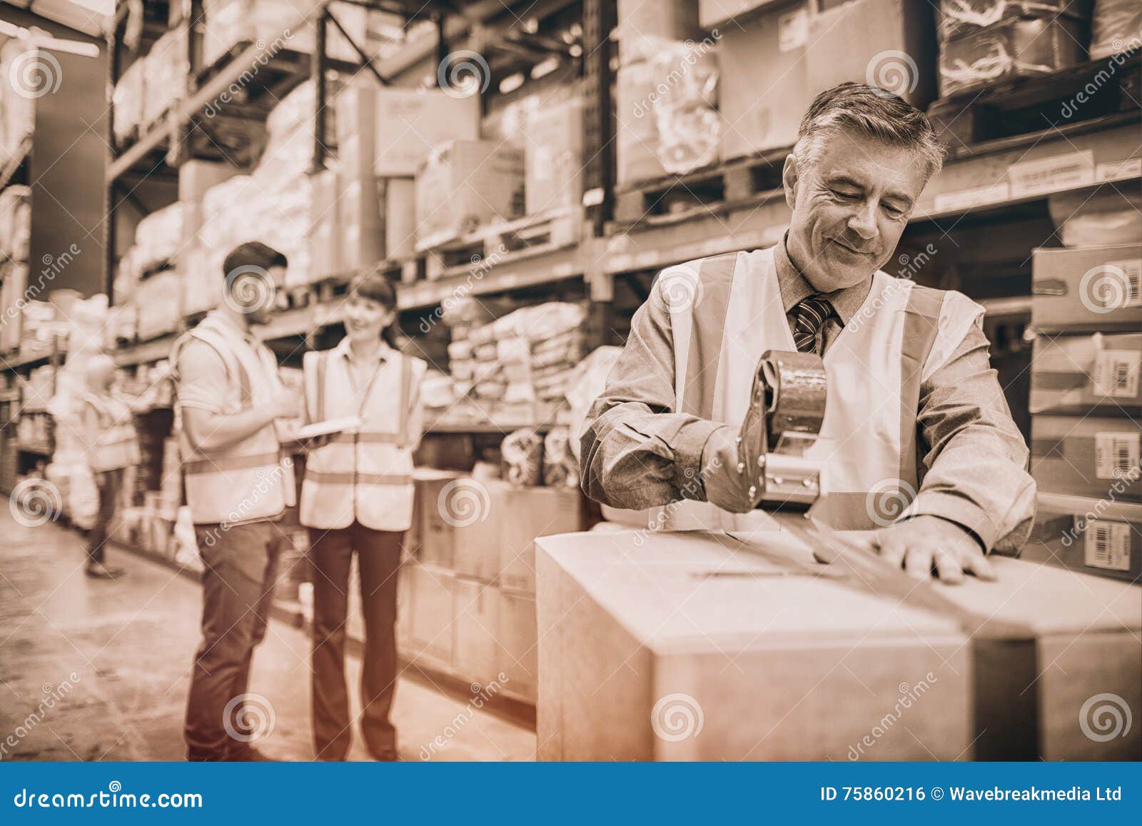 Warehouse Worker Sealing Cardboard Boxes for Shipping Stock Photo