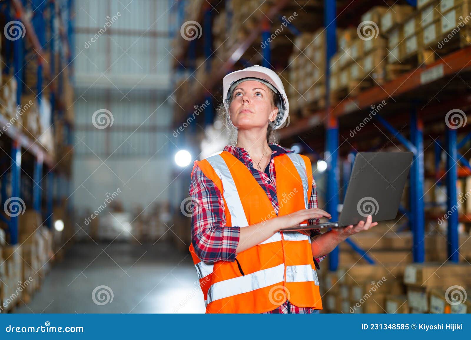 Warehouse Worker Working Process Checking the Package Using Laptop in
