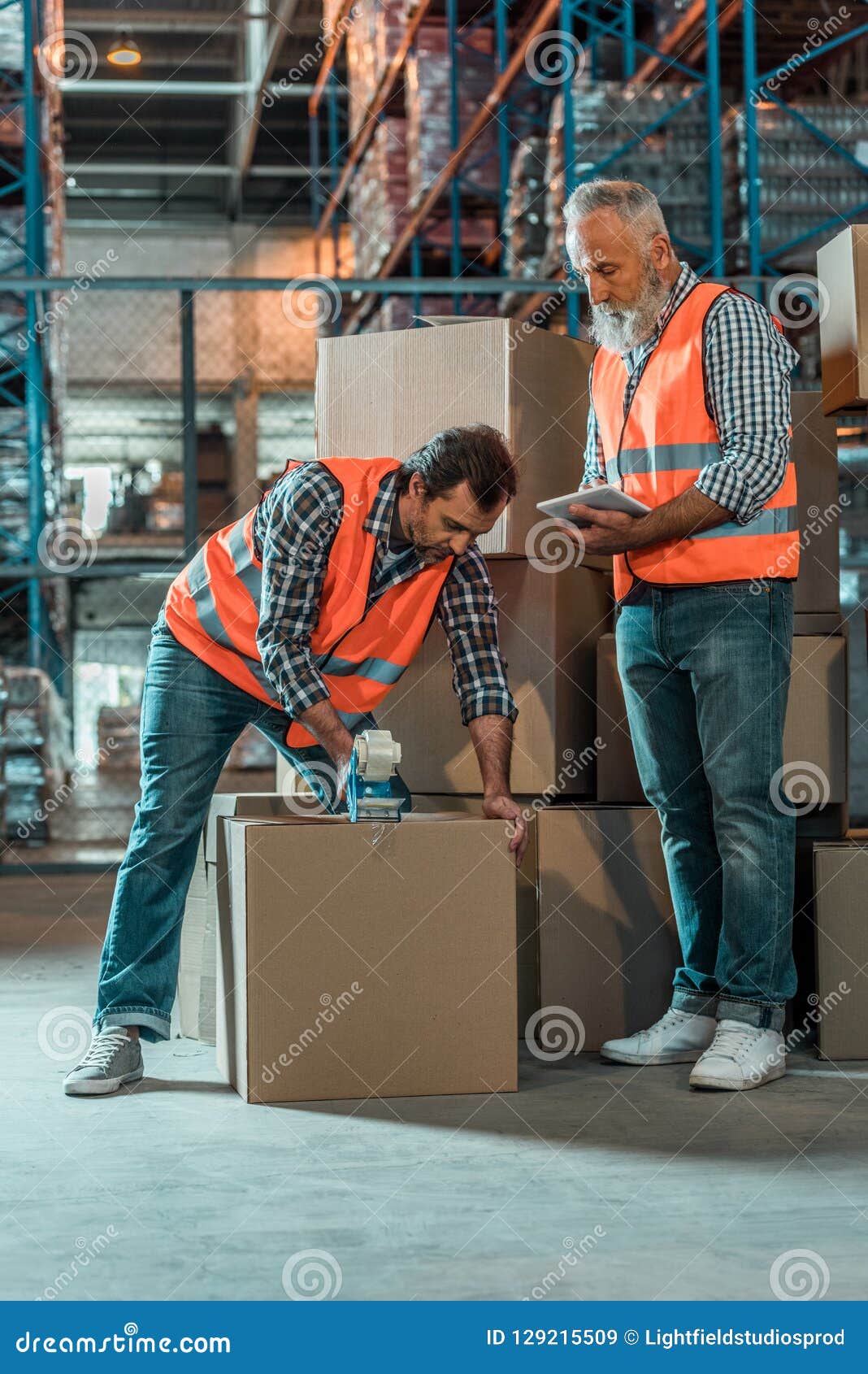 Warehouse Workers with Digital Tablet and Adhesive Tape Working Stock