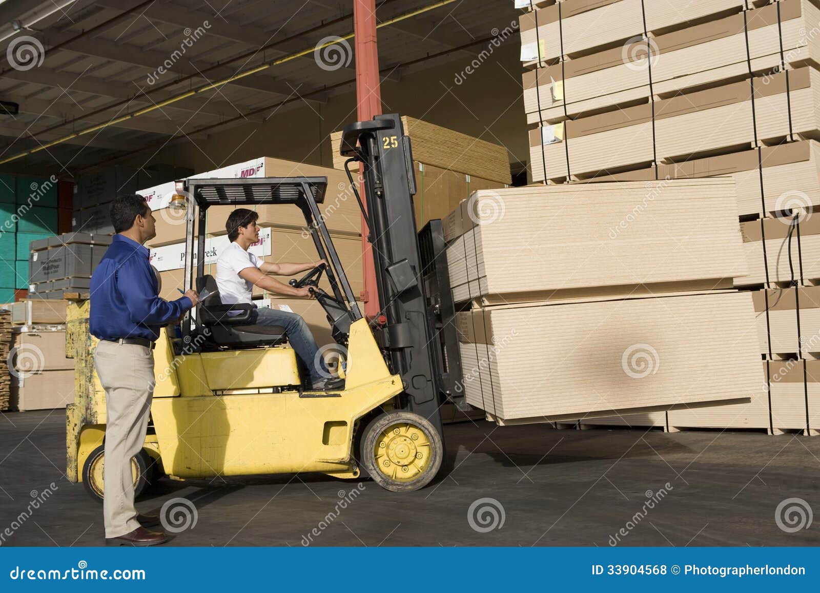 Warehouseman and Forklift Truck Driver in Timber Factory Stock Photo