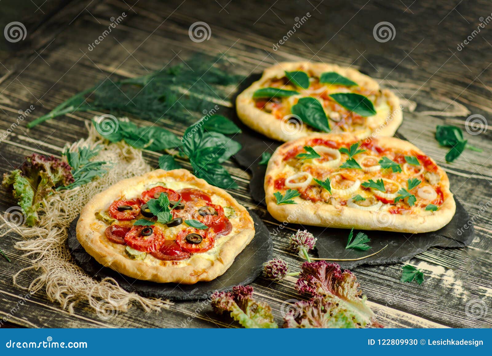 wariety pizza on wooden board and various ingredients