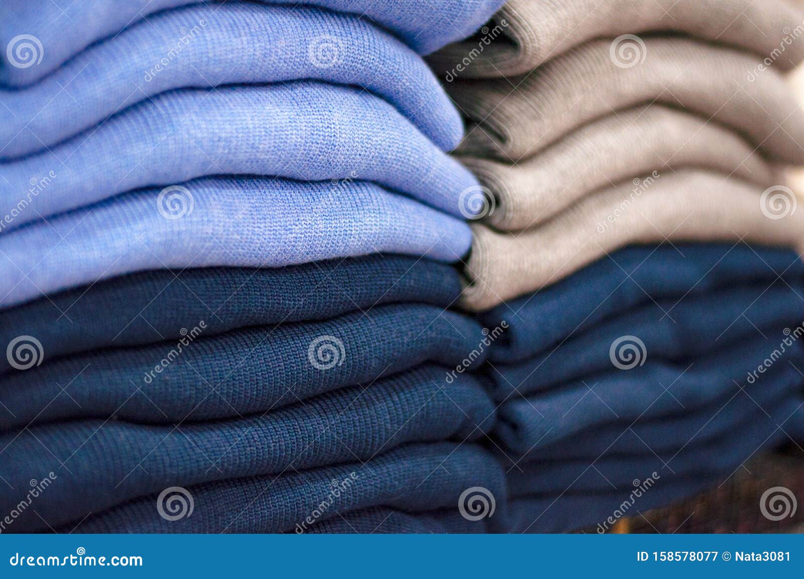 Warm Clothing Neatly Folded on a Store Shelf. Sweatshirts, Sweaters ...