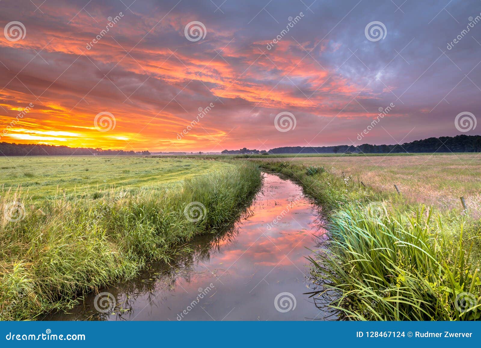warm colored summer sunrise over lowland river