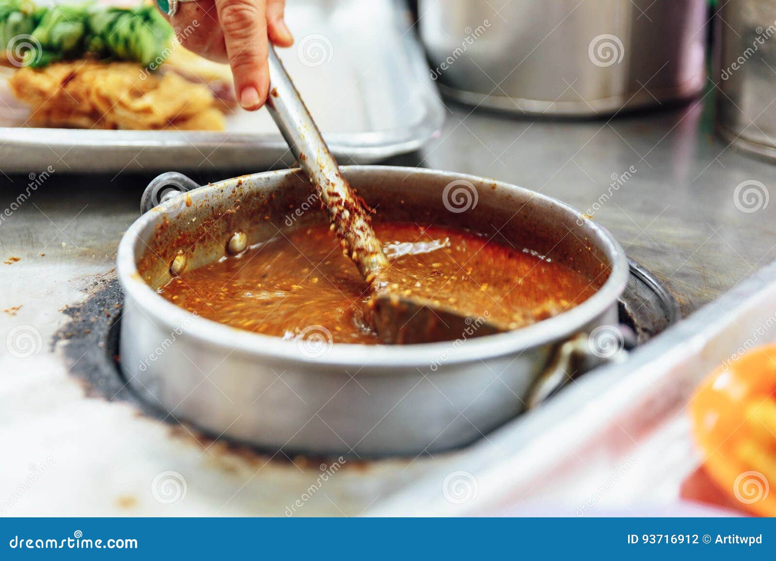 warming satay sauce in the pot. satay is a dish of skewered grilled meat with javanese origins in malacca city, malacca, malaysia