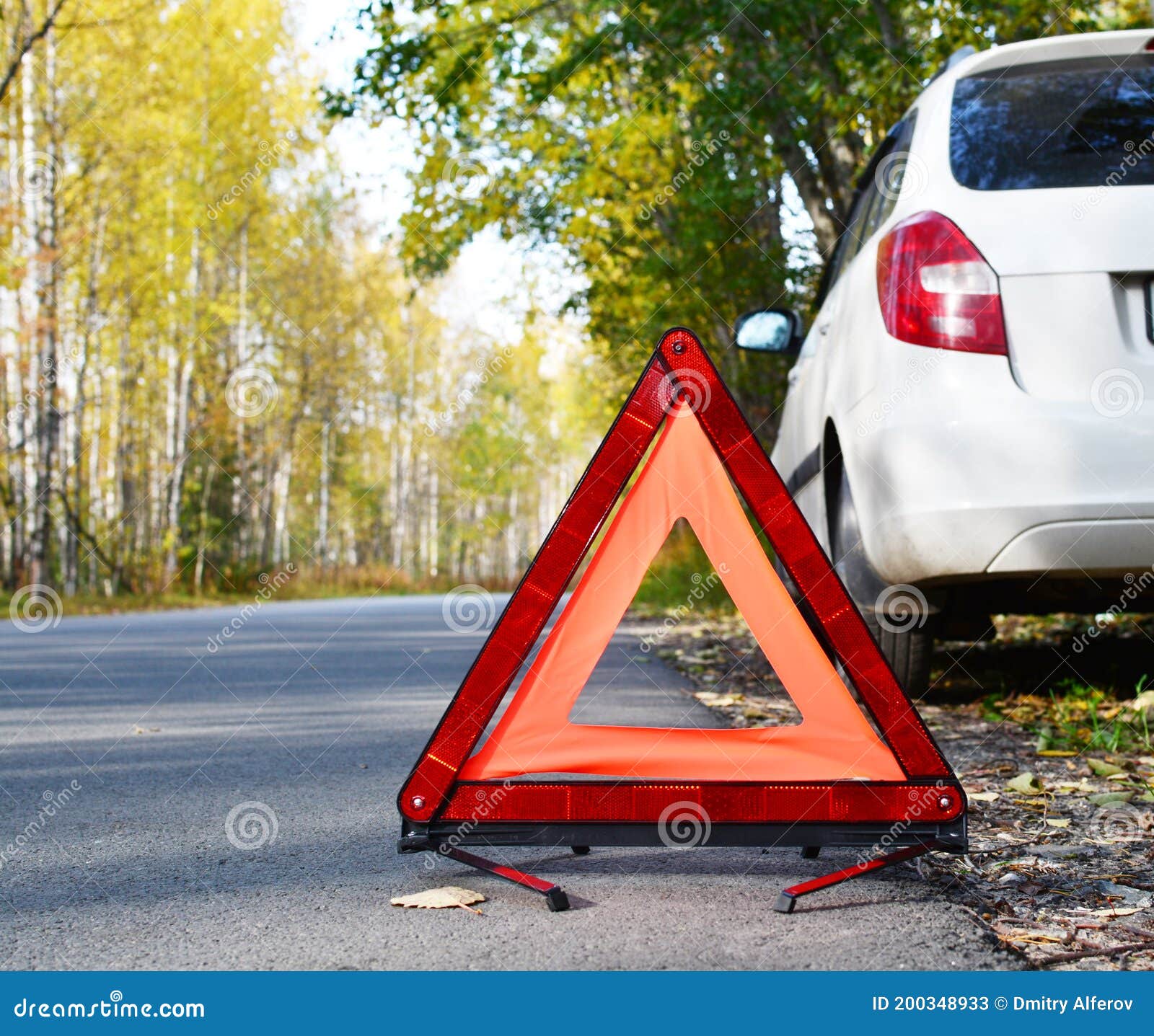 warning stop sign on the road against the background of a white car and forest. concept of roadside assistance, travel incidents,