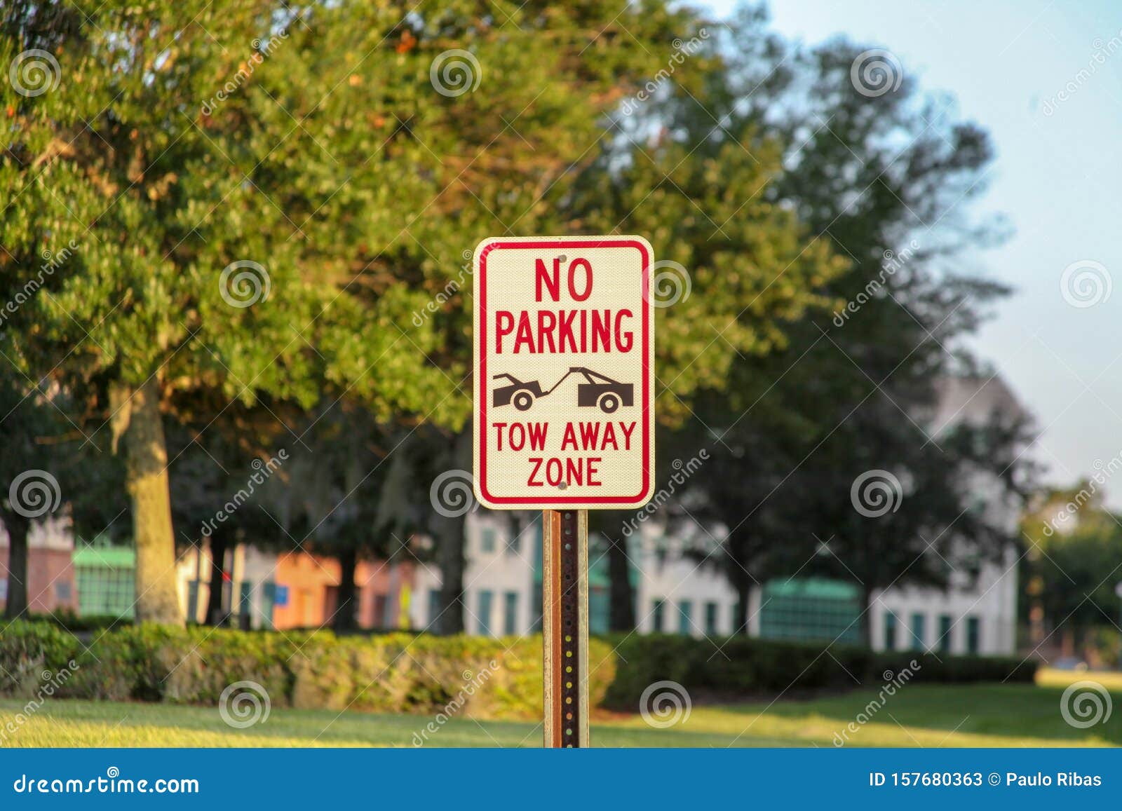 Warnzeichen: Es gibt keinen eigenen Parkplatz mit Schleppvorrichtung Im Hintergrund schöne Gebäude und Landschaft in mit Büschen am späten Nachmittag in Celebretion, Florida