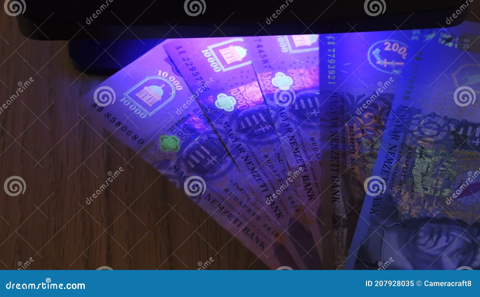warsaw, poland 01.01.2021 hungarian forint uv lamp anti-counterfeiting test. luminescent ink patterns got visible under
