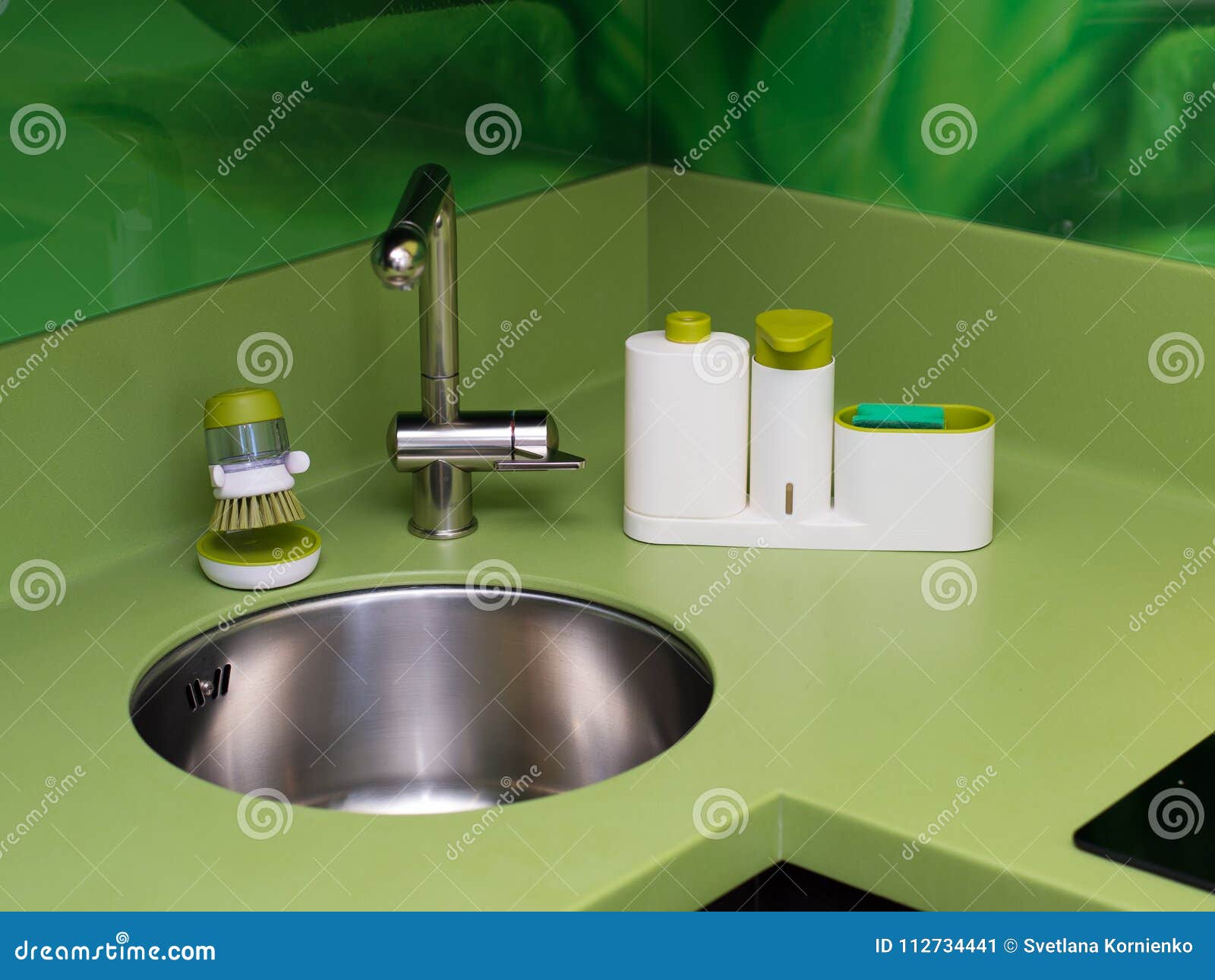 Wash dishes beautifully sponge green in the kitchen cleanliness of the faucet