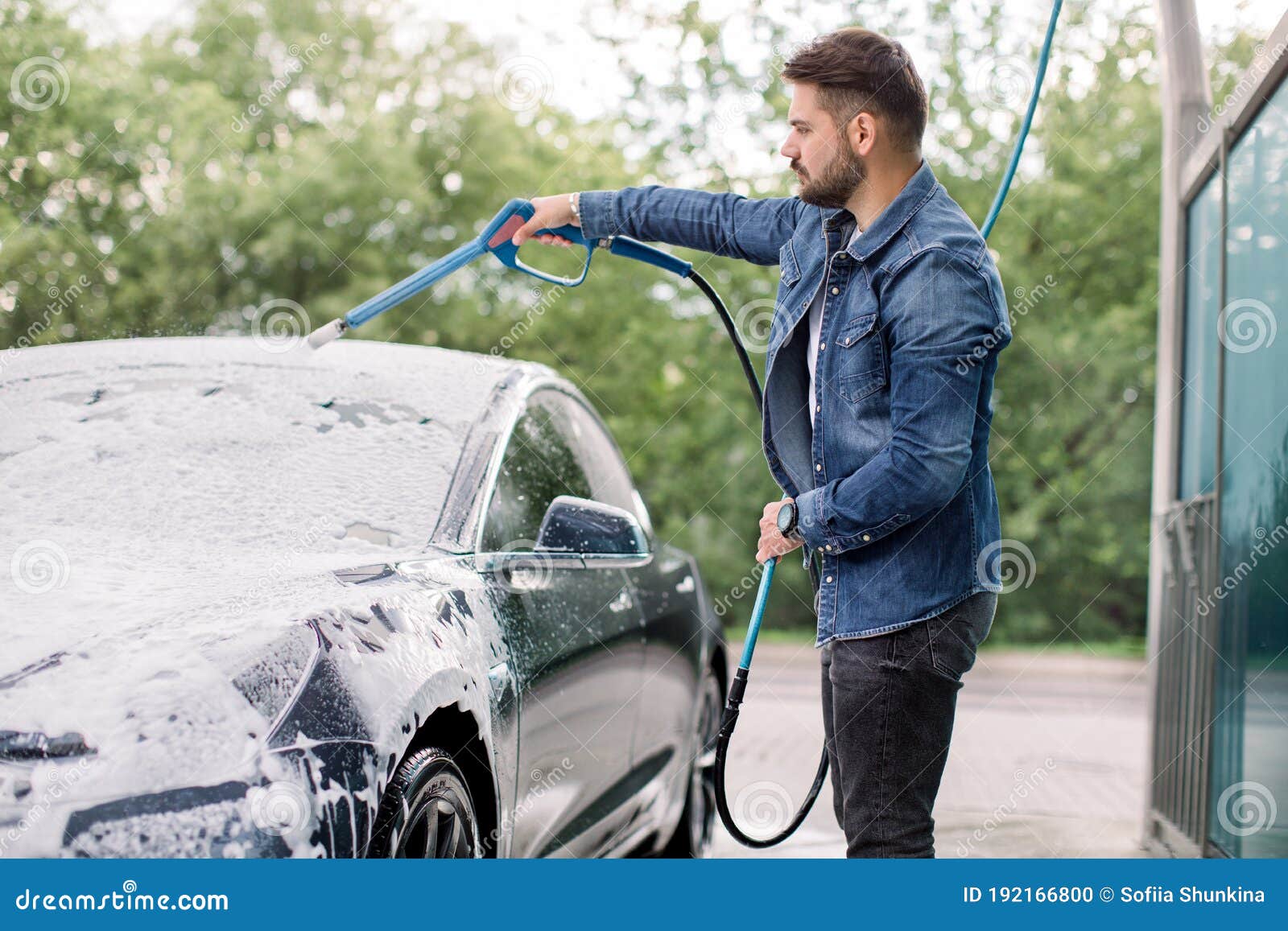 Premium Photo  A man washes his car at a selfservice car wash using a hose  with pressurized water