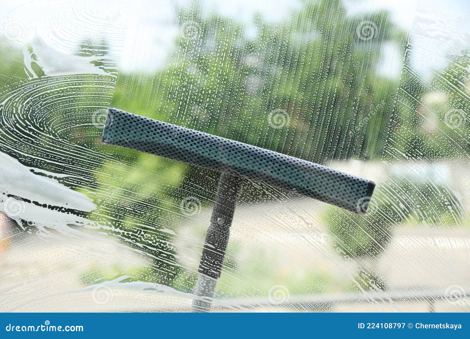 Washing Window with Squeegee from Outside, View through Glass Stock