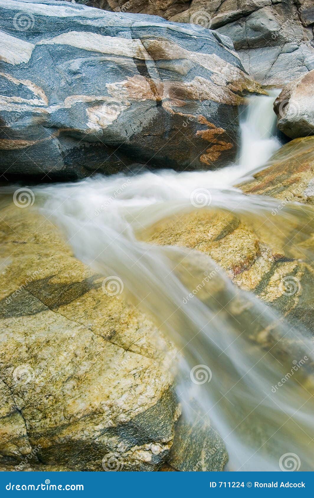 Wasserfall, der über Felsen fließt. Ein Gebirgsstrom stellt einen kleinen Wasserfall über Mosaik gekopierten Felsen her.