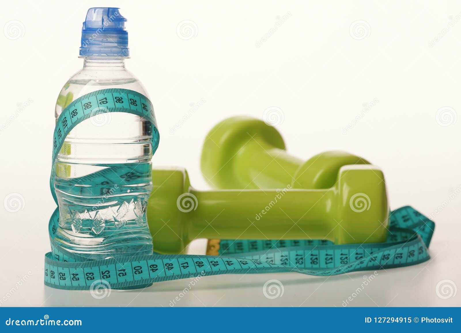 Water bottle tied with cyan measure tape on white background