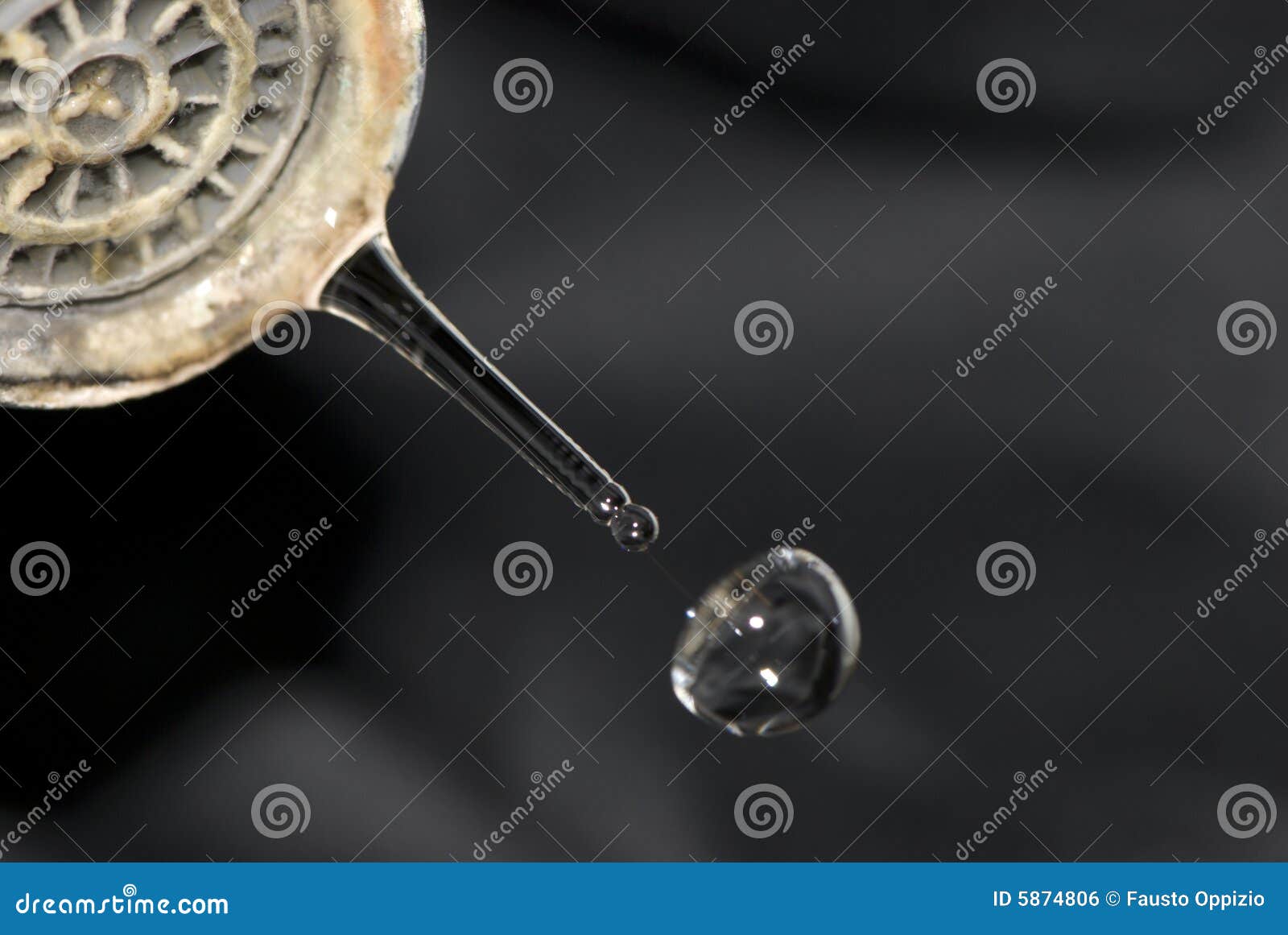 Water drop from old tub on darck background