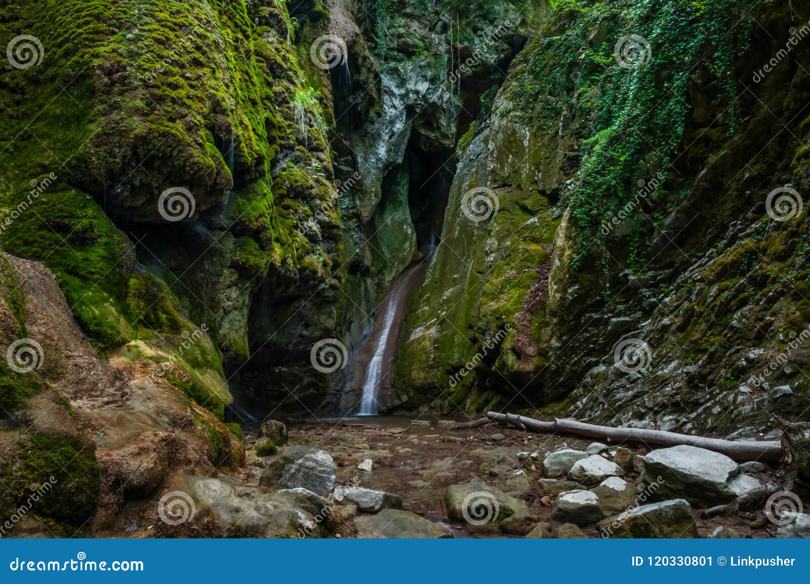 Water Flow Into Creek And Waterfall In Mountain Gorge Between Rocks