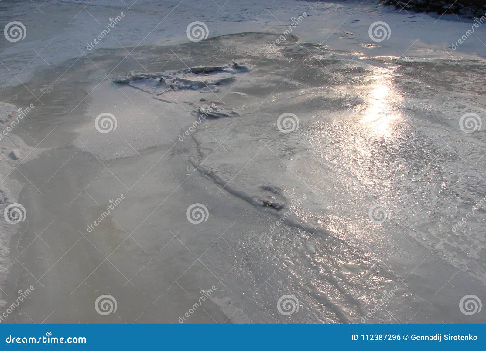 The water mirror is covered with ice of the Dnieper River near the Khortitsa Island in the frosty winter. city of Zaporozhye. Ukra. Natural patterns of the ice surface of the Dnieper River, where the sun`s rays appear in a clear, frosty day.