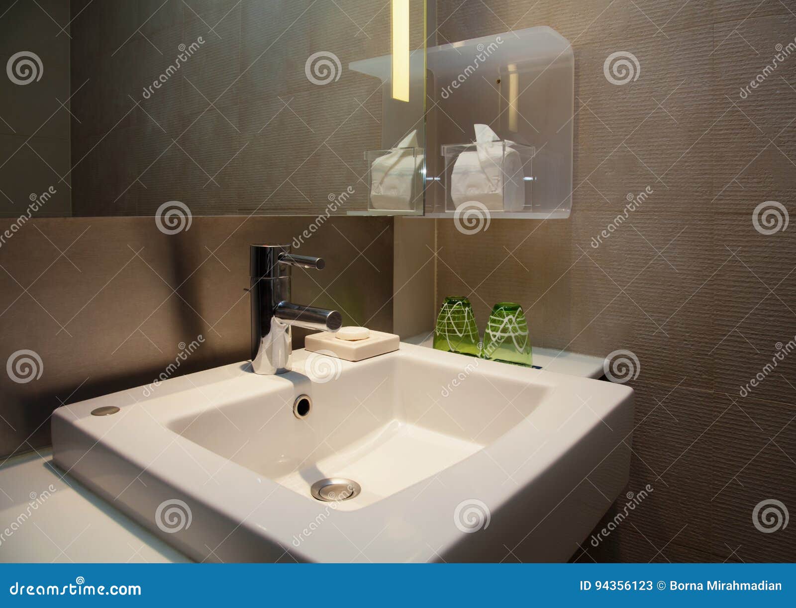 Water Tap And Ceramic White Sink In A Modern Wc With Brown Tiles