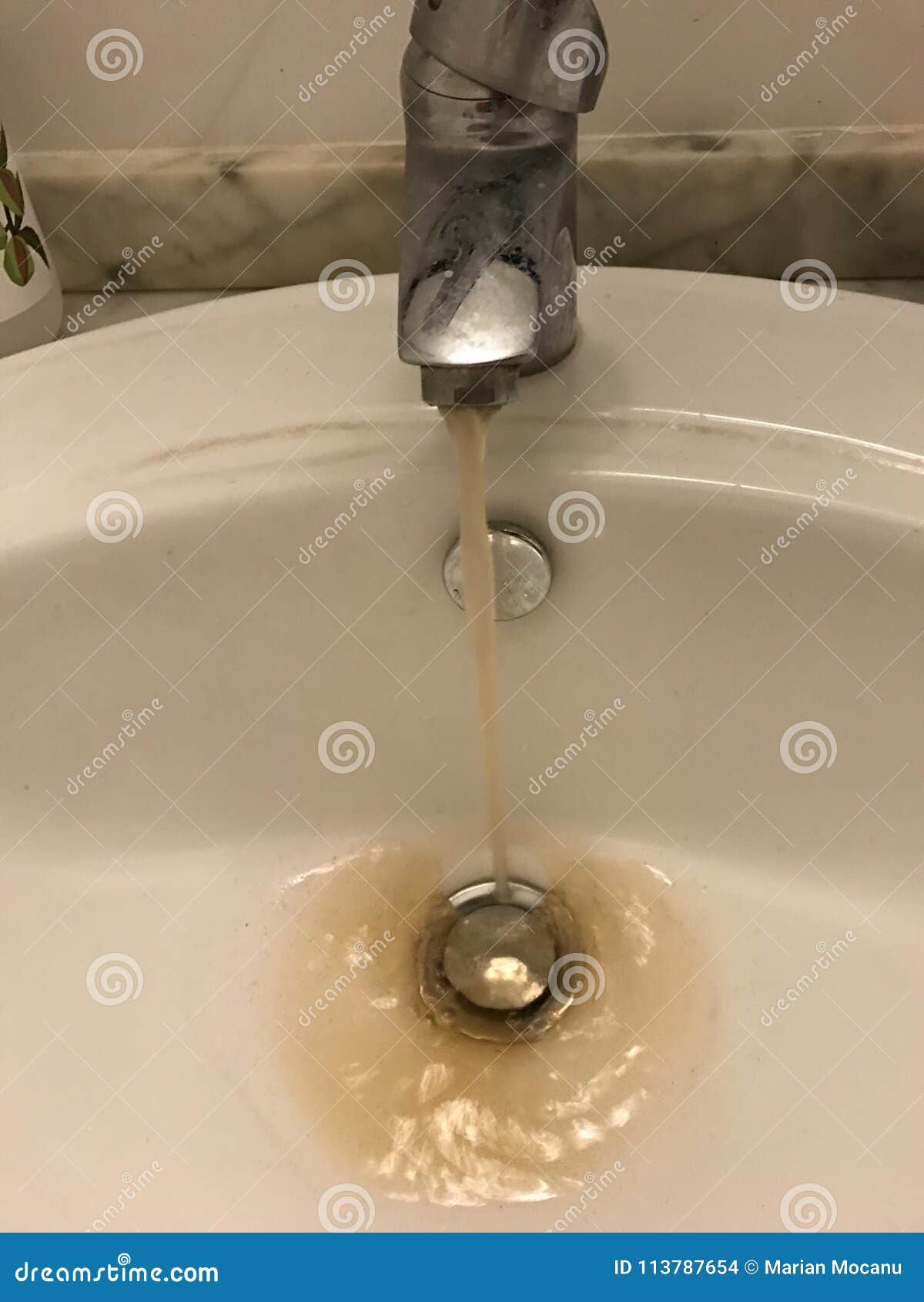 Water Tap With Running Dirty Muddy Water In A Sink Stock Photo