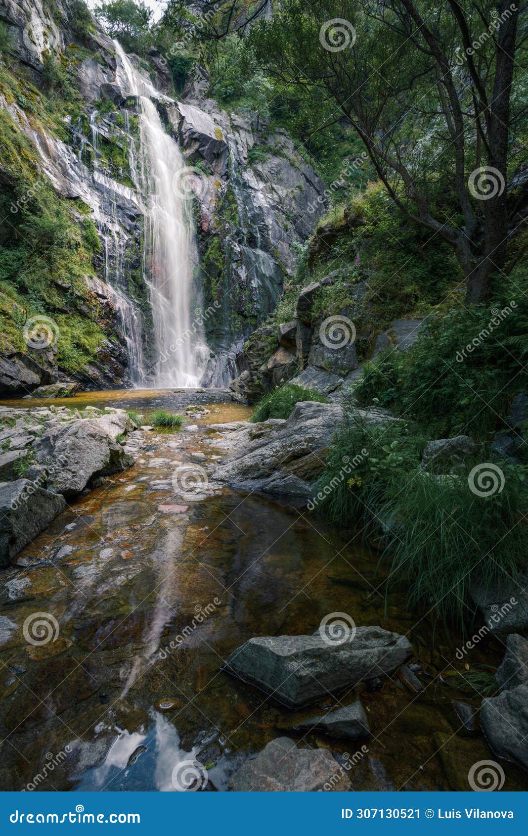 waterfall caresses the granite rock before falling into a pool and forming a stream