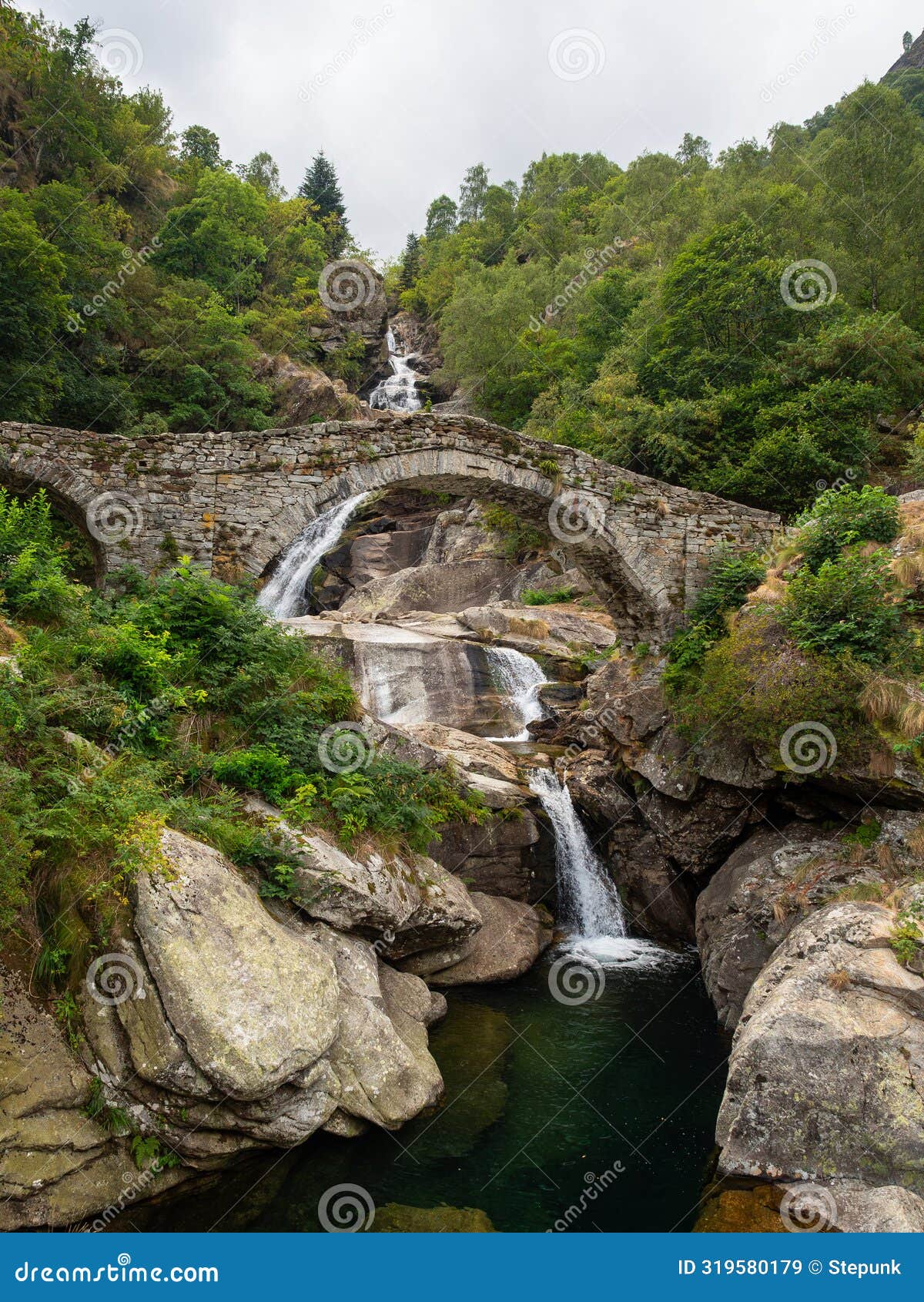 waterfall near fondo in valchiusella, piemonte, italy, with old bridge