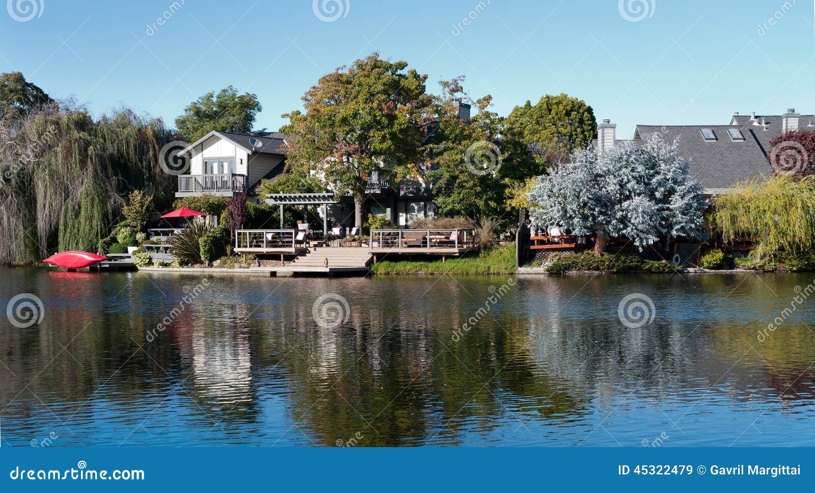 waterfront property with doc and red canoe