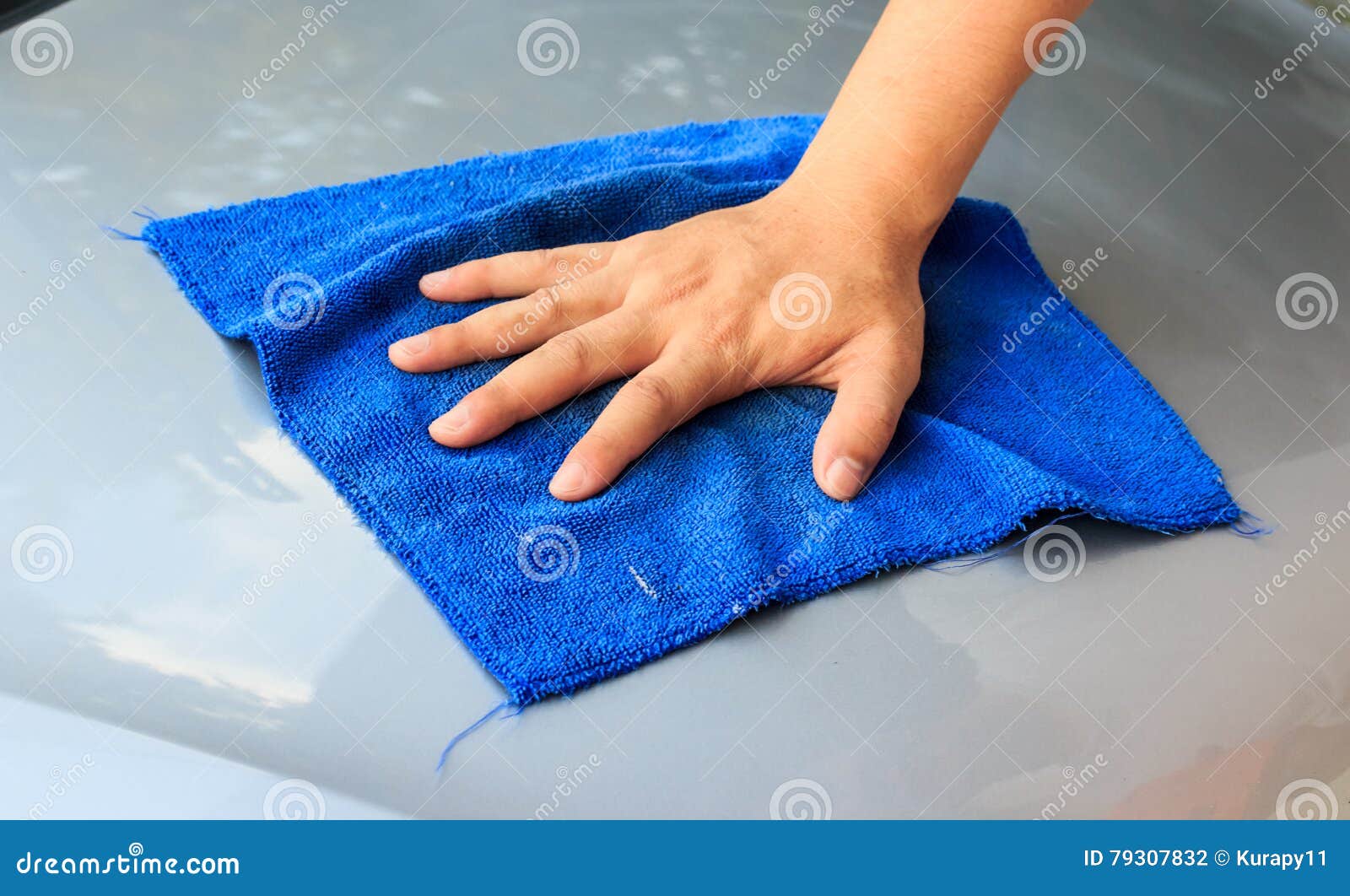waterless car wash. men`s hand with blue cloth cleaning car