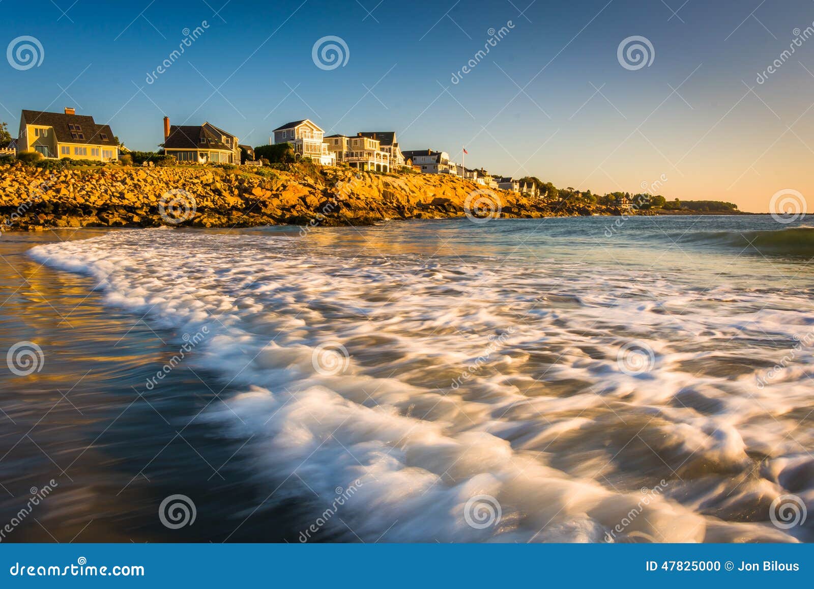 Waves in the Atlantic Ocean and Houses on Cliffs in York, Maine. Stock