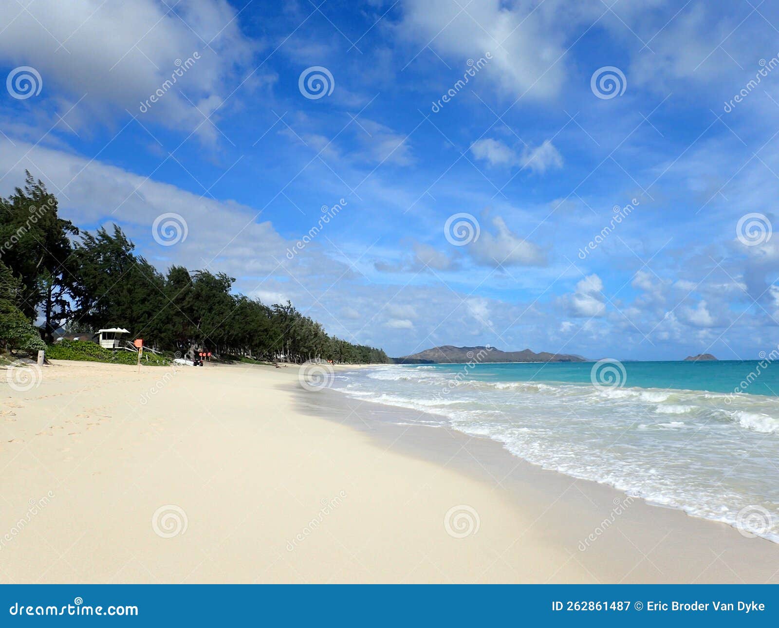 waves lap on shore with lifeguard tower on waimanalo beach