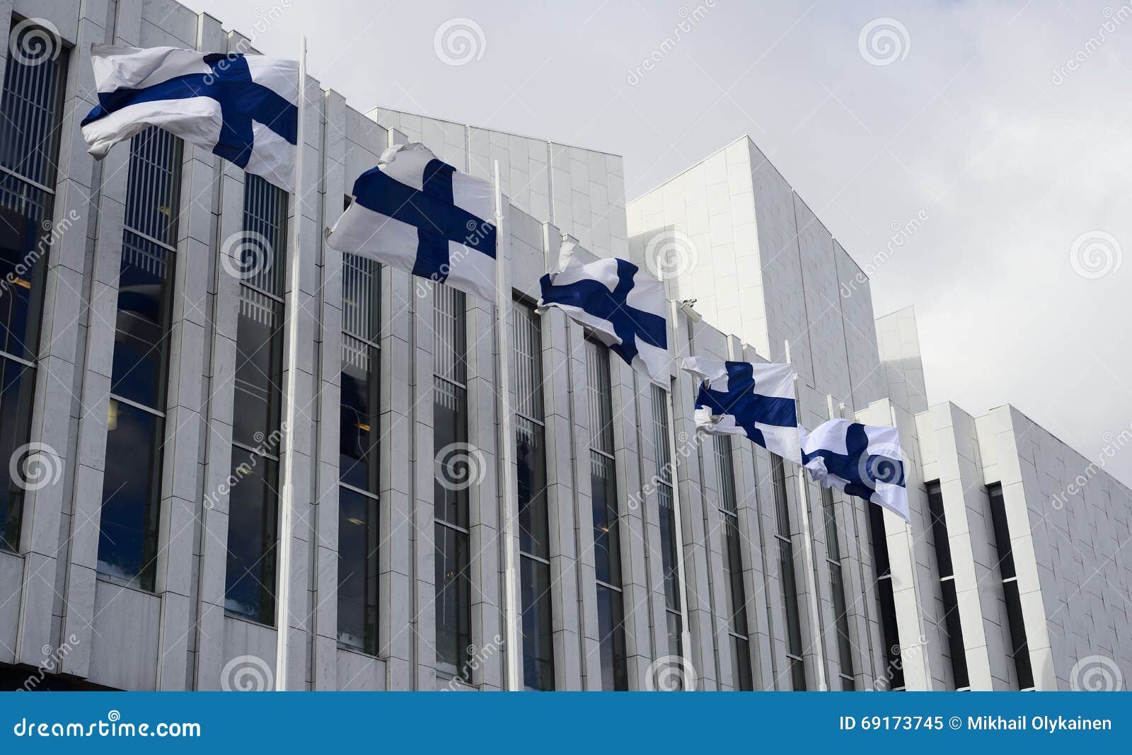 waving finnish flags against of the finlandia hall