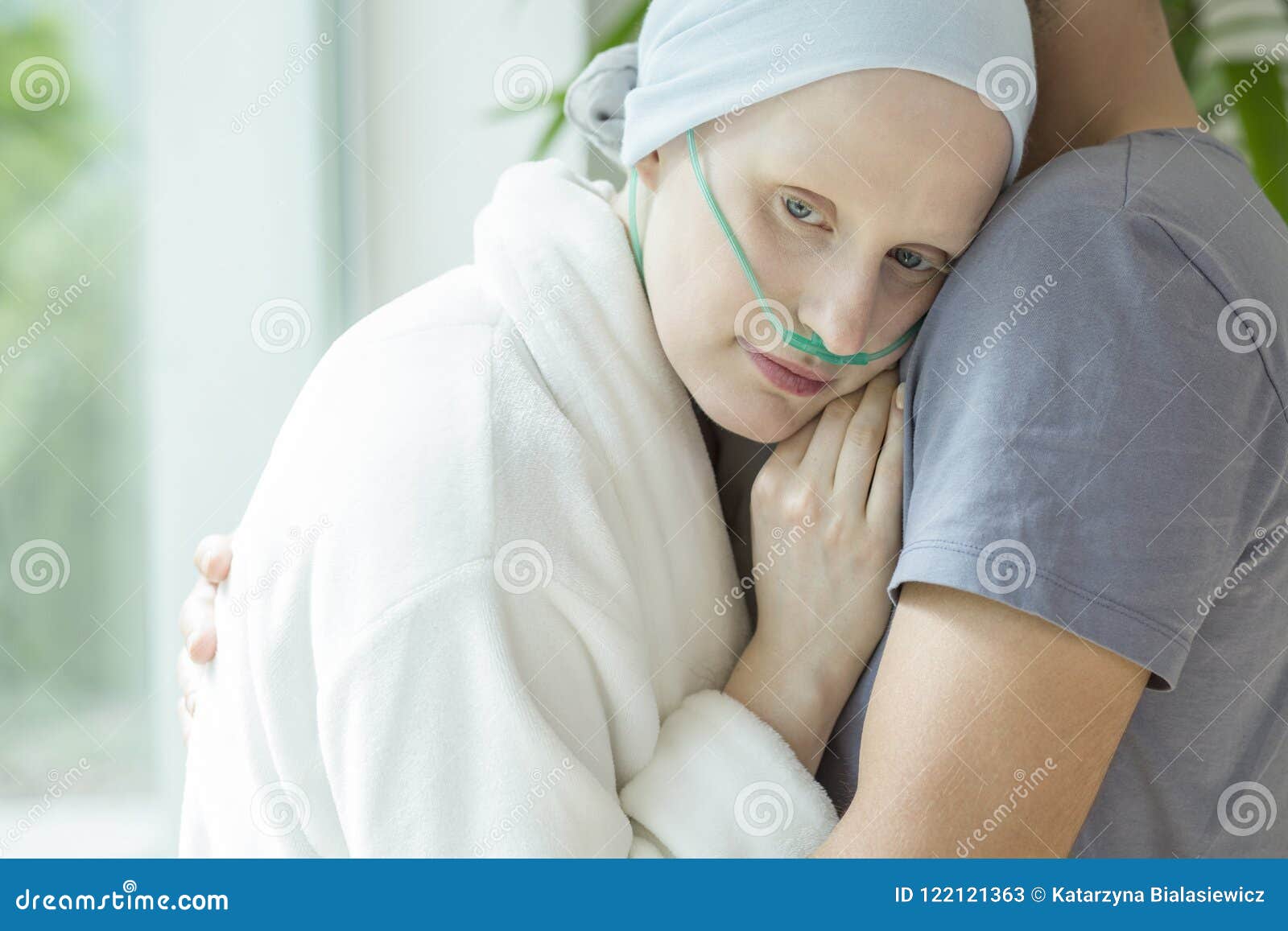 weak woman with cancer hugging her husband during chemotherapy