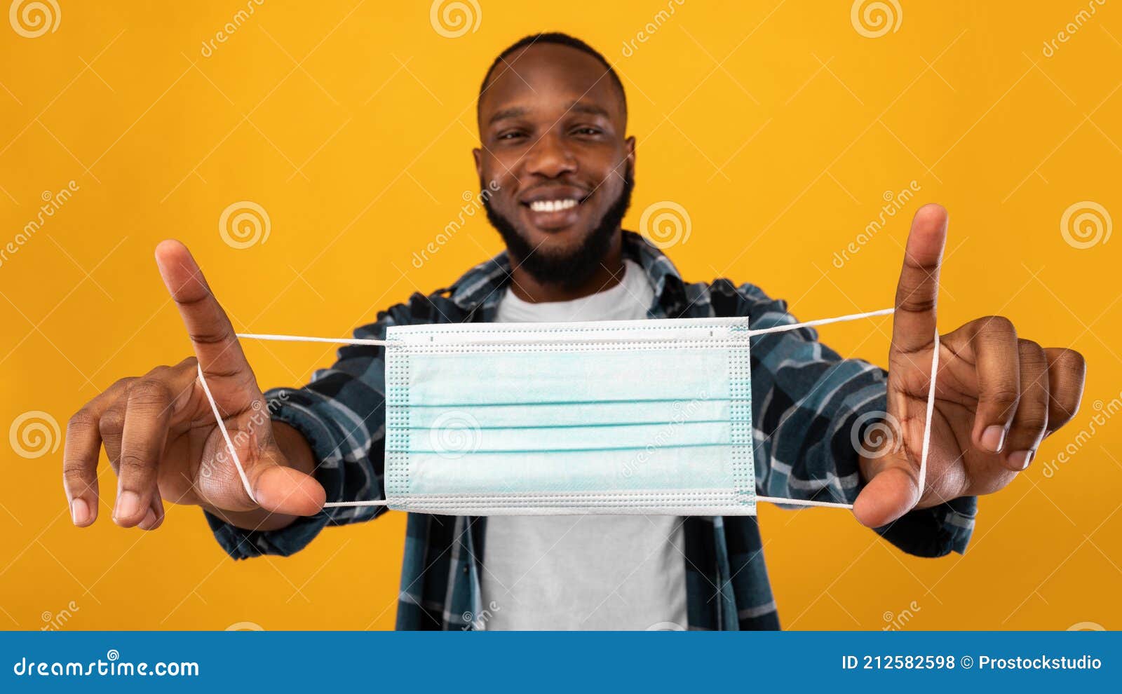 African Guy Offering To Wear Face Mask Over Yellow Background Stock ...