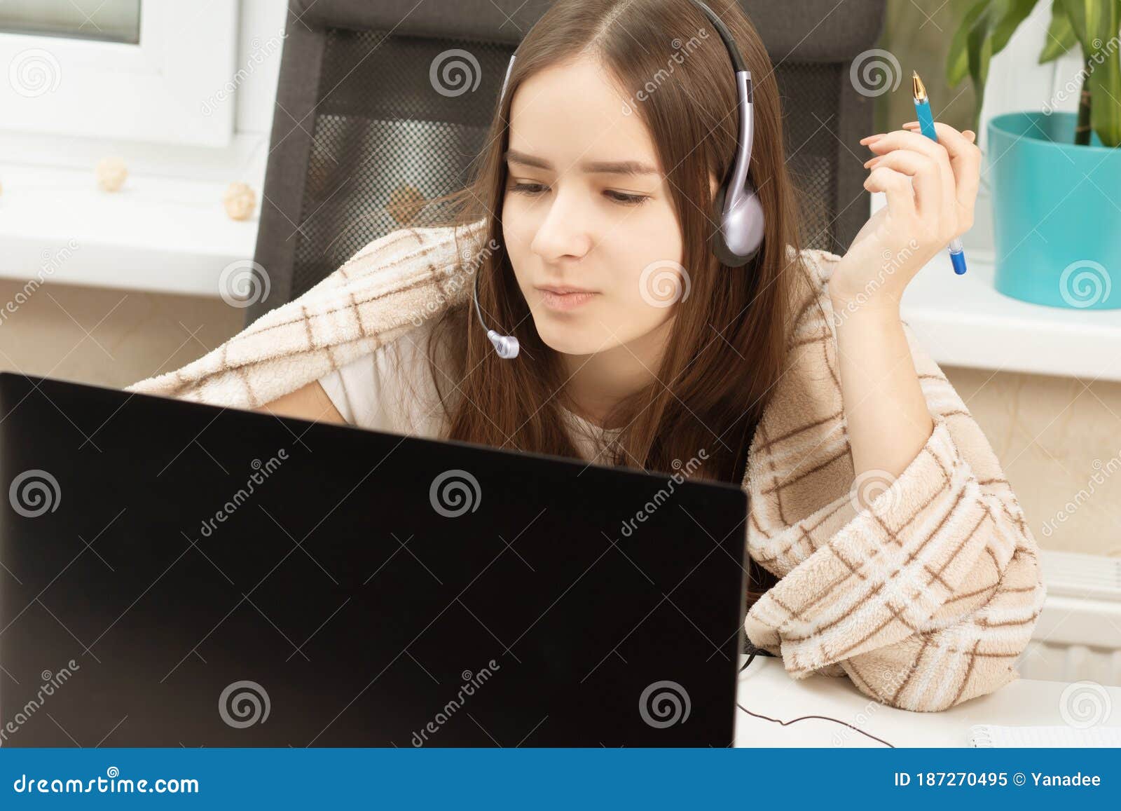 inar. Girl in Headphones with a Microphone in Front of a Laptop