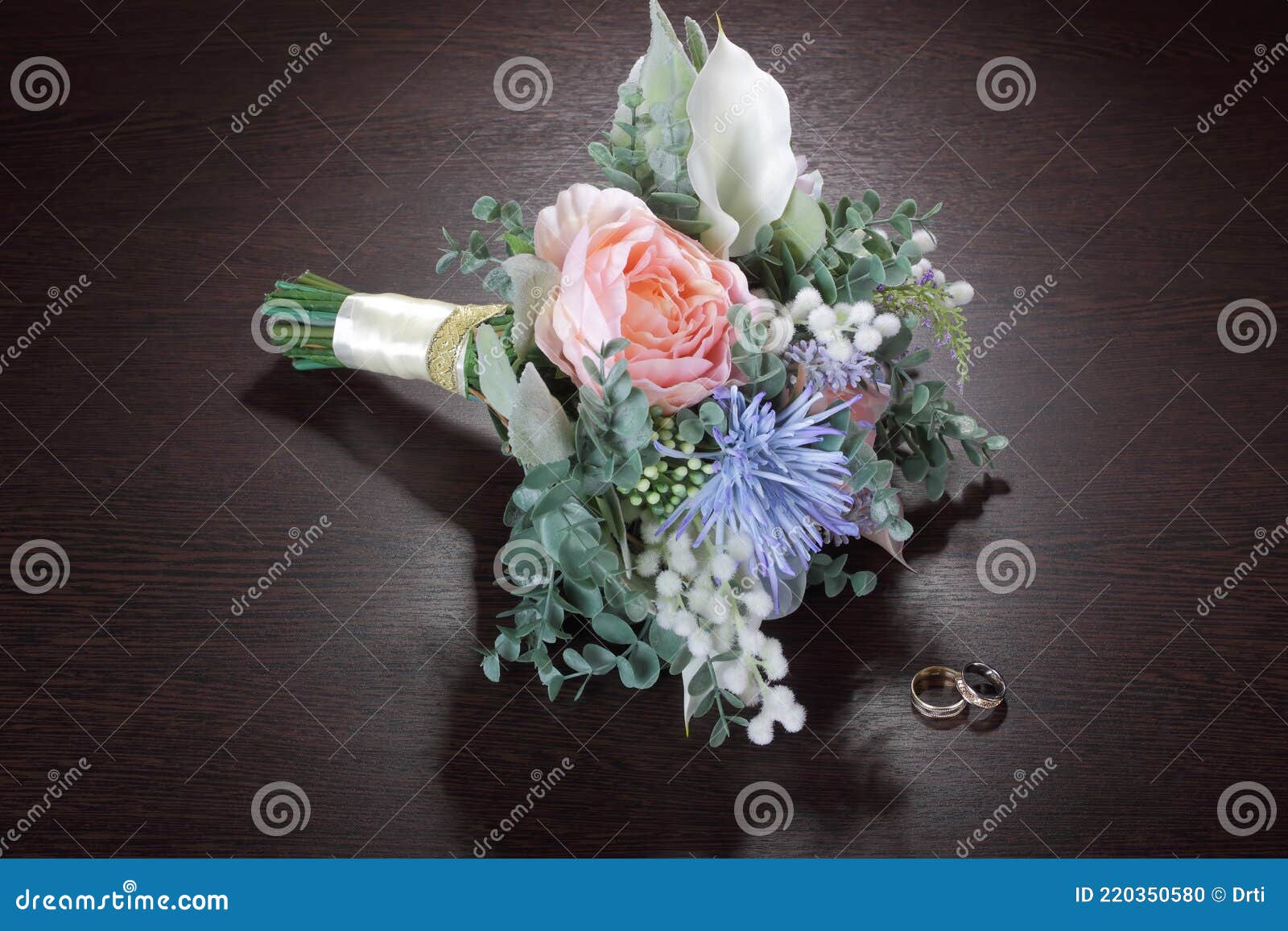 Wedding Bouquet of Artificial Flowers and Wedding Rings on the Table