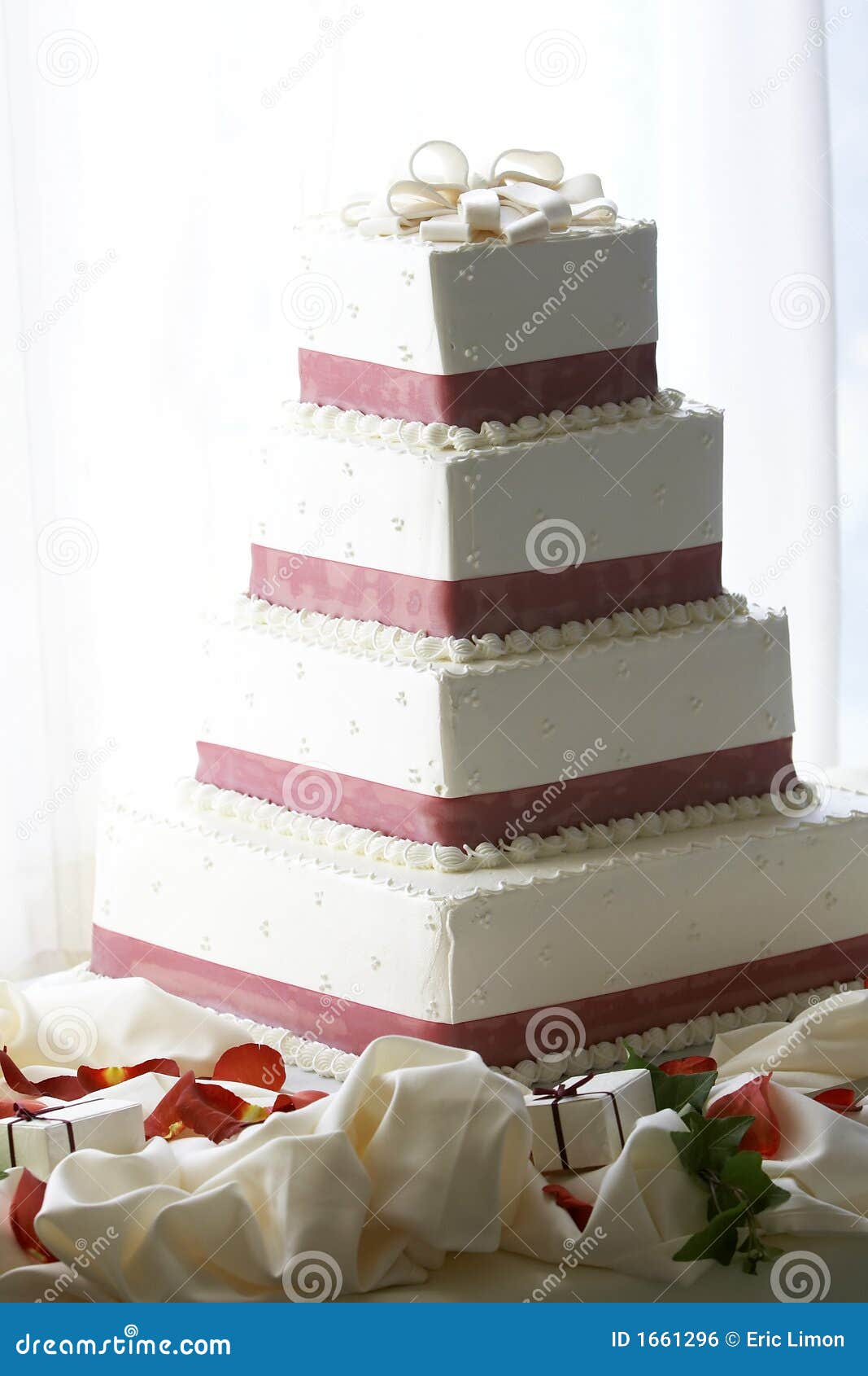 A four tiered wedding cake, heavily back lit with blown out background